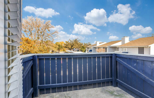 a blue fence with a house in the background