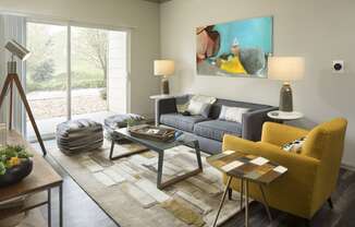 a living room with a gray couch and yellow chair