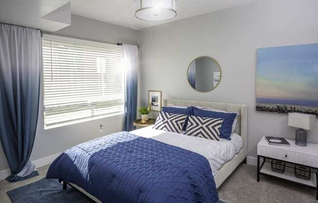 a blue and white bedroom with a bed and a window