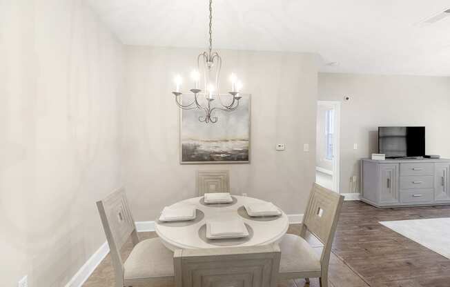 a dining room with a table and chairs and a chandelier at Highlands in Bartlett, TN