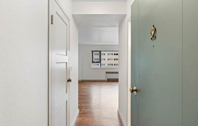 an empty room with a door open to a living room