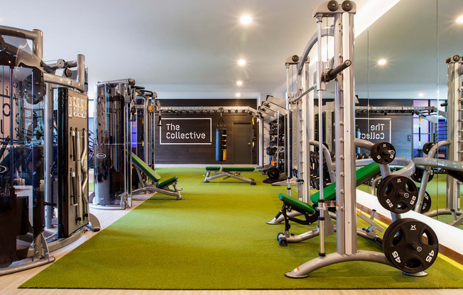 A gym with a green floor and a sign that says "The Collective".