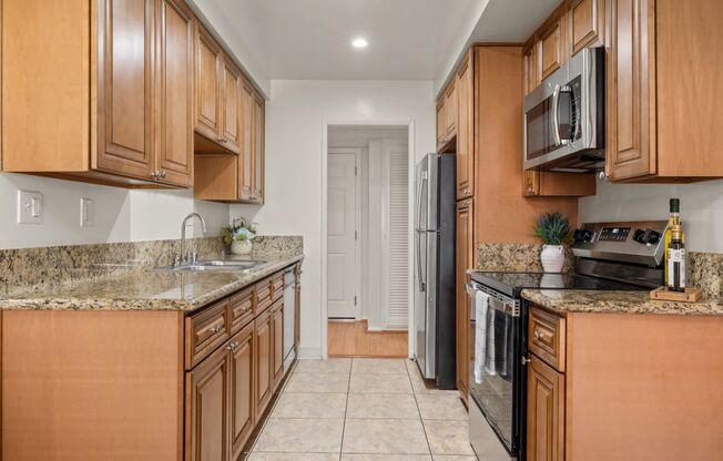 a kitchen with wooden cabinets and granite counter tops