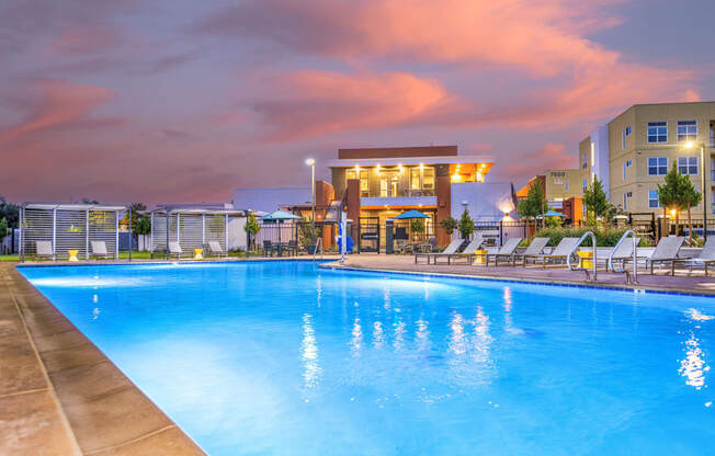 apartments swimming pool lounge area with apartment buildings in background at twilight at Solasta, Sacramento, CA, 95831