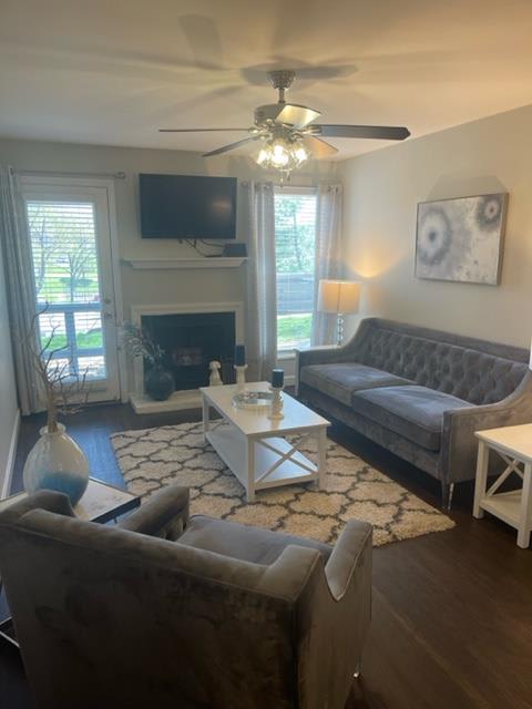 a living room with couches and a table and a ceiling fan