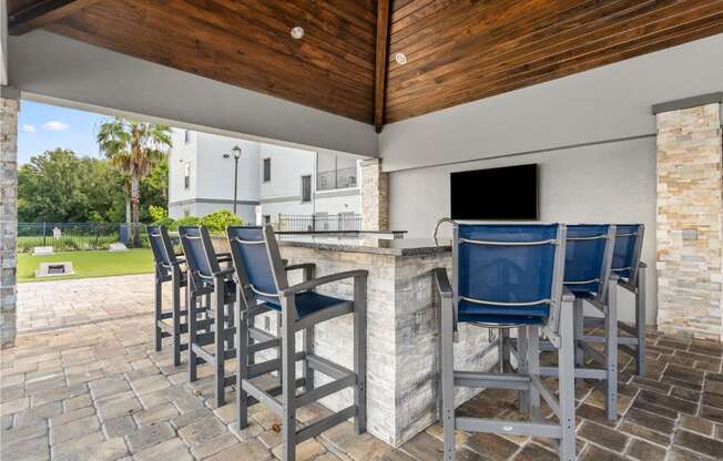 A patio with a bar and chairs.