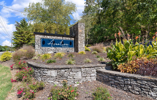 a stone retaining wall with a sign in front of it