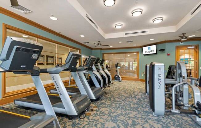 a gym with a row of treadmills and other exercise equipment