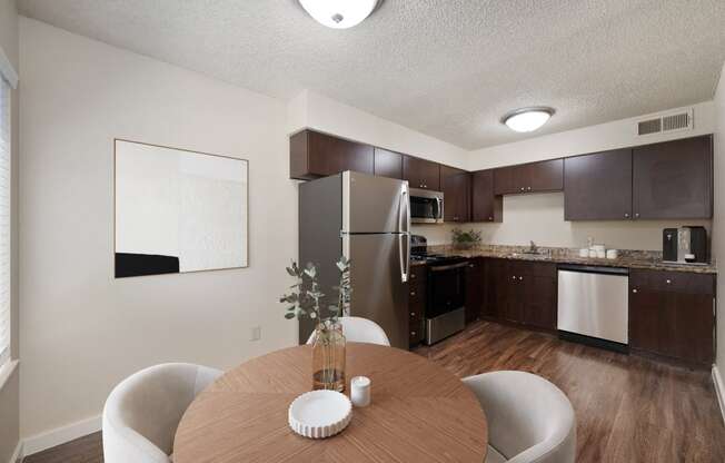 a kitchen and dining room with stainless steel appliances and a wooden table