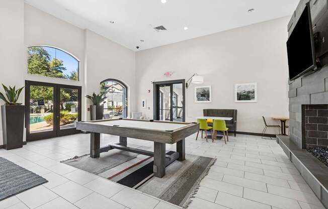 A modern living room with a pool table and a fireplace.