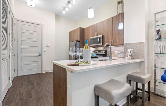a kitchen with a bar and stools in a 555 waverly residences apartment
