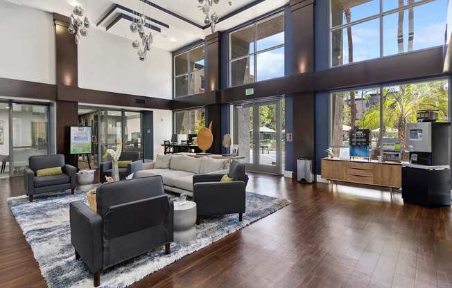 A large room with a lot of furniture and a view of trees outside the windows at The Kitt at Warner Center Apartments, Woodland Hills