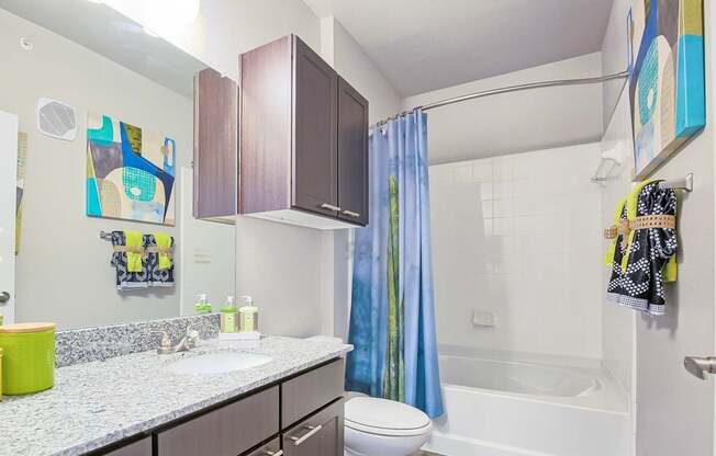 A bathroom with a white sink and a blue shower curtain.