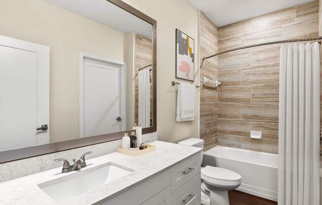 A bathroom with a sink, toilet, and bathtub.