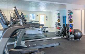 a room filled with lots of cardio equipment and weights