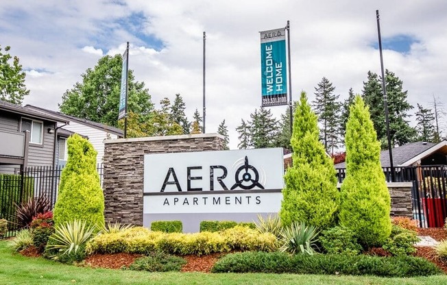 A sign for Aero Apartments is displayed in front of a building.