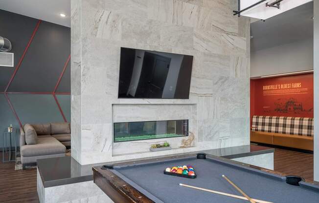 A pool table with a green cloth and a set of pool balls on it.