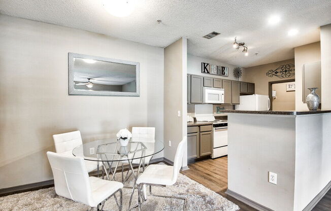 A modern kitchen with a glass table and chairs.