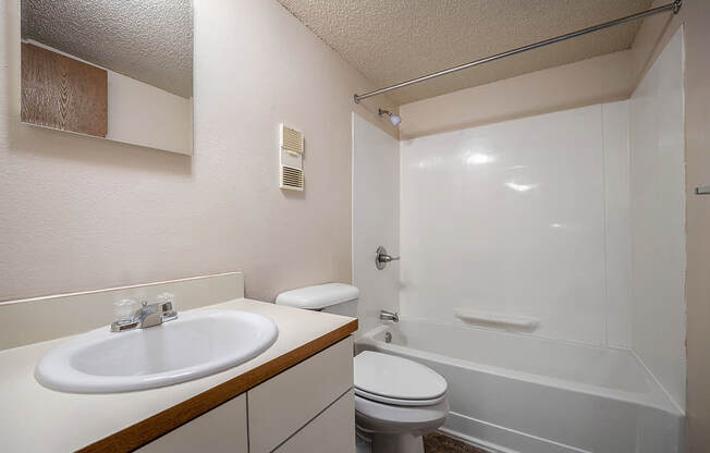 A toilet, sink, bathtub, and mirror in a bathroom at Seville Apartments, Michigan