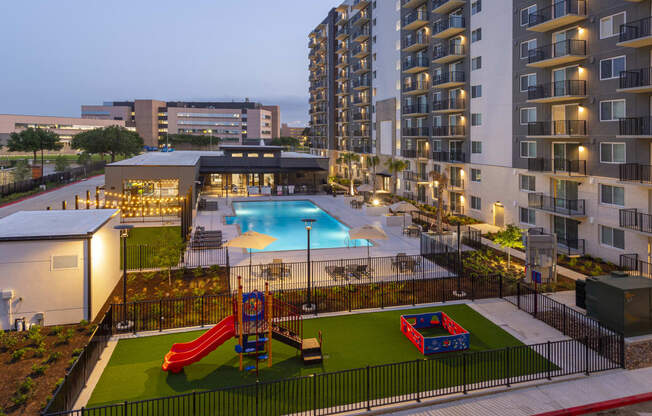 an aerial view of an apartment complex with a pool and playground