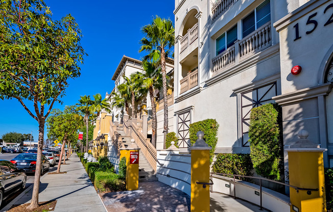 a row of apartment buildings with palm trees in the background