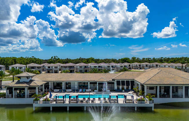 A resort with a pool and a fountain in the foreground.