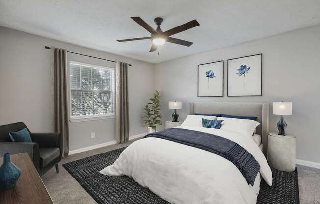 A bedroom with a large bed and a ceiling fan.