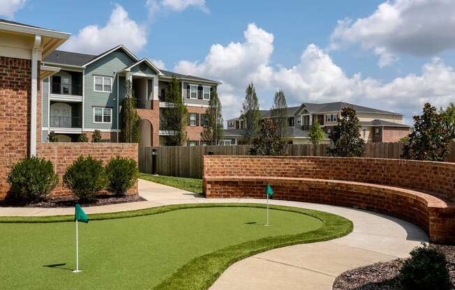 an image of an apartment building with a golf course in front of it