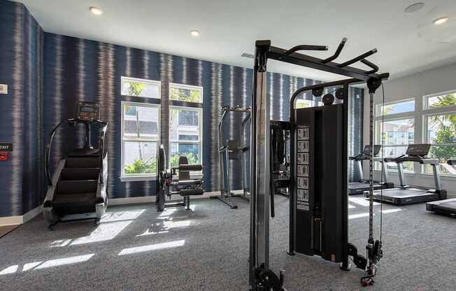 A gym with a variety of equipment including a treadmill, a stationary bike, and a weight machine.