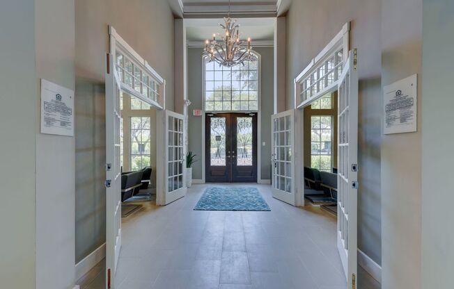 a hallway with two doors and a chandelier