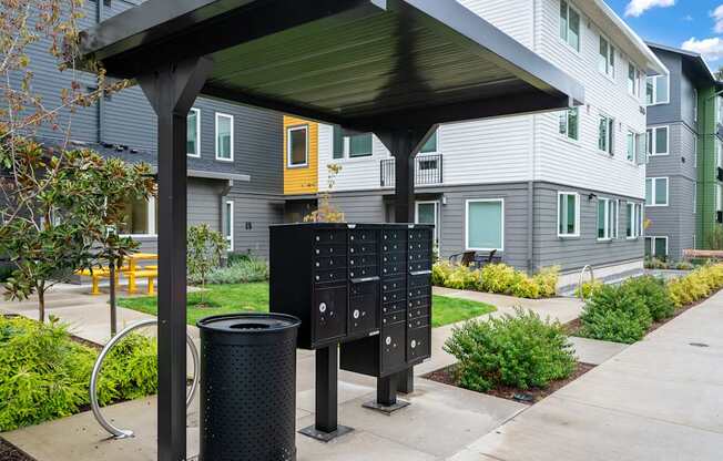 a covered picnic area with a trash can in front of a building