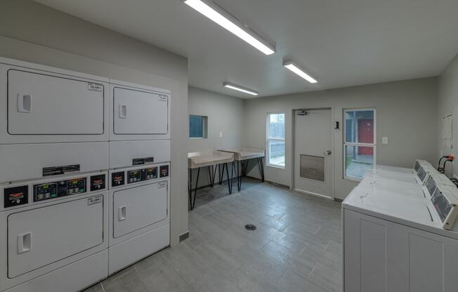 a laundry room in a building with washes and dryers