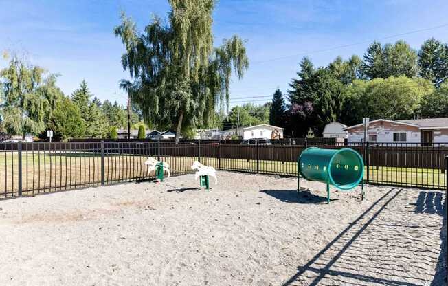 A playground with a green slide and a white slide.