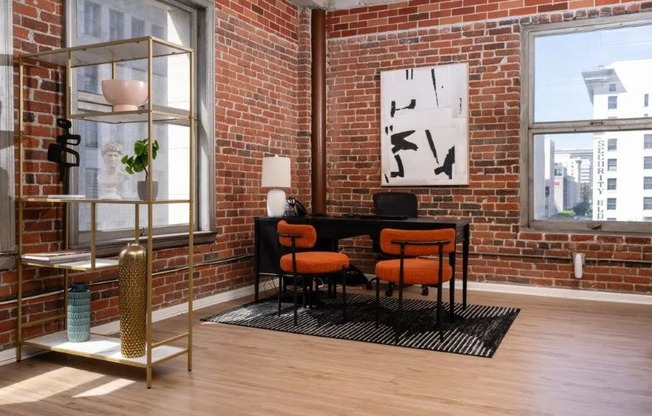 a room with chairs and a clock on a brick wall