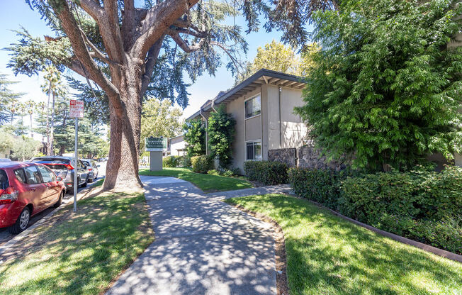 a house with a sidewalk and trees in front of it