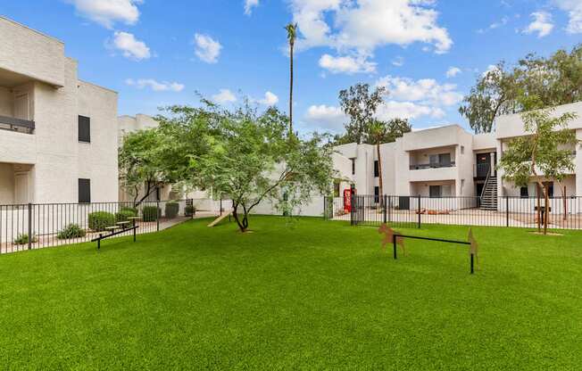 a grassy area with a bench and trees in the middle of a building