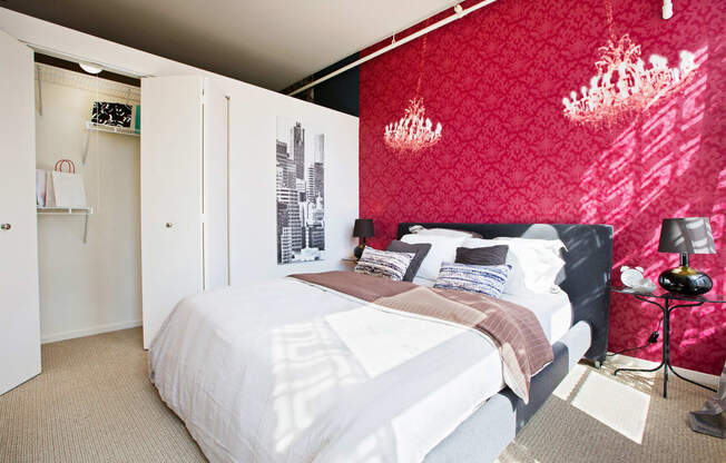 a bedroom with a red wall and a white bed