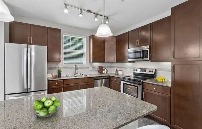 A kitchen with brown cabinets and a granite countertop.