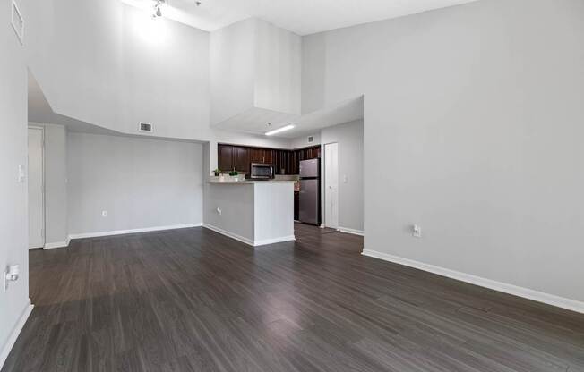 A spacious room with wood flooring and white walls.