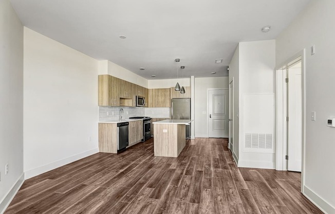A kitchen with wooden floors and white walls.