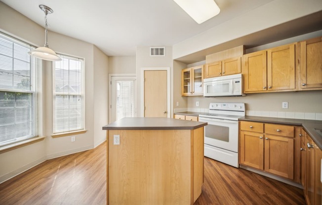 an empty kitchen with an island in the middle