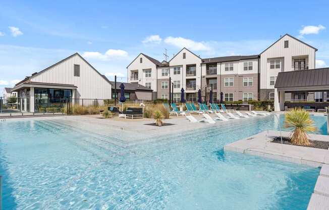 A large swimming pool in front of a resort.