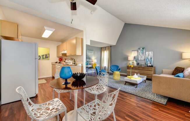 Living Room with View of Kitchen with Hardwood Inspired Floor, White Sofa, Rug and Blue Chairs