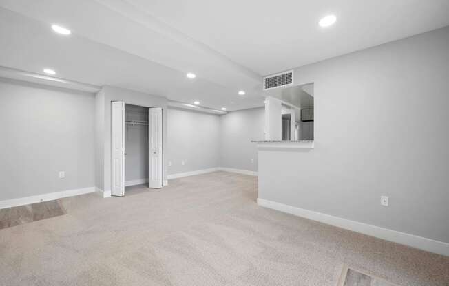 A spacious room with a carpeted floor and a doorway leading to another room.