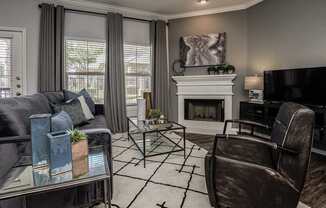 a living room with a couch and chairs and a fireplace