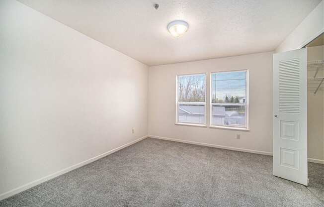 bedroom with a large window and walk-in closet at Canal 2 Apartments, Lansing, 48917