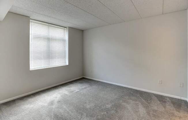 an empty room with a window and concrete floor