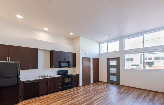 the view of a living room and kitchen in an empty apartment