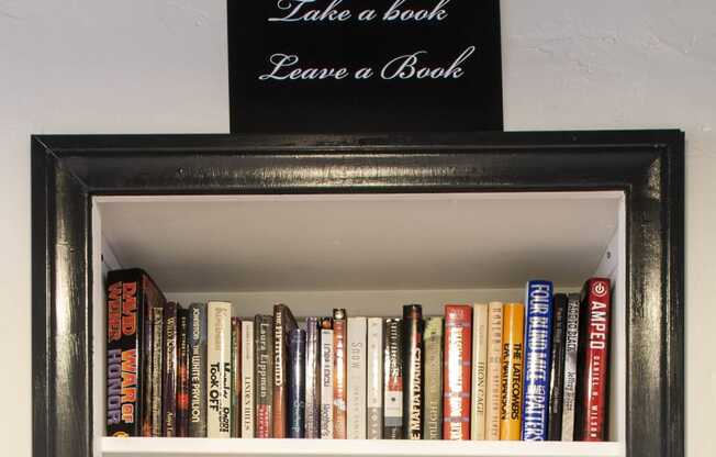 a book shelf with a sign saying loving library take a book bring a book at Del Mor, Los Angeles, 90026