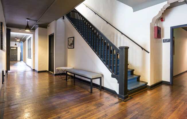 a hallway with a staircase and a wooden floor and a bench at Del Mor, Los Angeles]